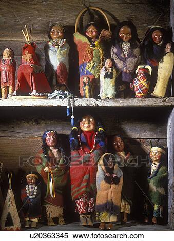 COLLECTION DISPLAYS - Vintage Native American dolls on display on shelves in rustic log home. Very colorful. View Large Photo Image Stock Photography - COLLECTION DISPLAYS - Vintage Native American dolls on display on shelves in rustic log home. Very colorful.. Fotosearch