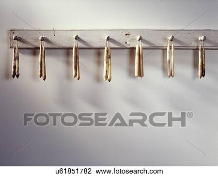 Stock Image - COLLECTION - Lard candles hanging from Shaker peg rail. . Fotosearch