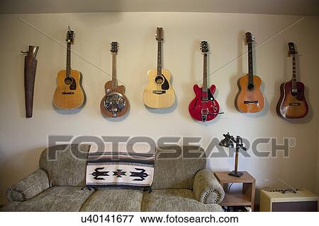Collection of guitars hanging on wall; Porterville; California; USA View Large Photo Image Stock Photo - Collection of guitars hanging on wall; Porterville; California; USA. Fotosearch