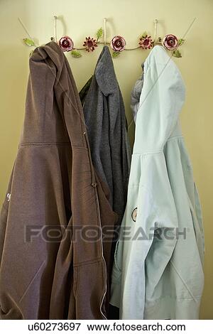 Stock Photo - Collection of hooded sweatshirts hanging on floral hooks; Carpinteria; California; USA. Fotosearch