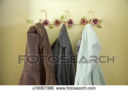 Stock Photograph - Collection of hooded sweatshirts hanging on floral hooks; Carpinteria; California; USA. Fotosearch