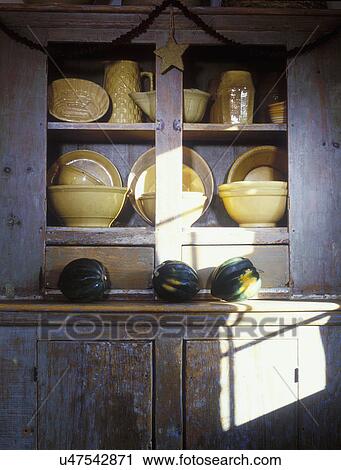 COLLECTION - Yellow ware pottery in antique distress painted cupboard, sunlit, acorn squash, garland with star, still life View Large Photo Image Stock Image - COLLECTION - Yellow ware pottery in antique distress painted cupboard, sunlit, acorn squash, garland with star, still life. Fotosearch