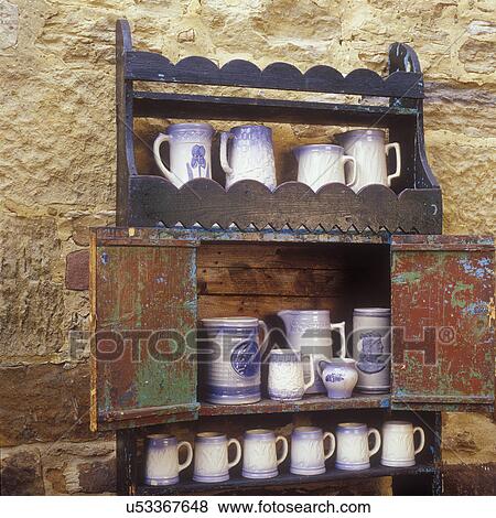 COLLECTIONS DISPLAYS - An antique open cupboard made by German immigrant in 1850. A collection of Salt Glaze Pottery on shelves, stone wall as background, Mineral Point Wis, Jail House Antiques View Large Photo Image Stock Photo - COLLECTIONS DISPLAYS - An antique open cupboard made by German immigrant in 1850. A collection of Salt Glaze Pottery on shelves, stone wall as background, Mineral Point Wis, Jail House Antiques . Fotosearch