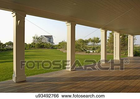 Stock Photograph - Colonnade with floorboard in single family home. Fotosearch