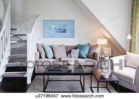 Comfortable sofa by staircase in contemporary living room View Large Photo Image Stock Photo - Comfortable sofa by staircase in contemporary living room. Fotosearch