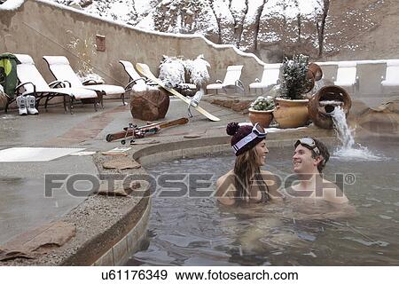 Stock Photo - Couple in heated swimming pool during the winter. Fotosearch