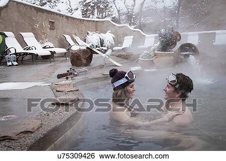 Stock Photograph - Couple in heated swimming pool during the winter. Fotosearch