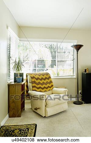 Stock Photo - Cozy armchair with throw blanket in living room, San Diego, California, United States of America. Fotosearch