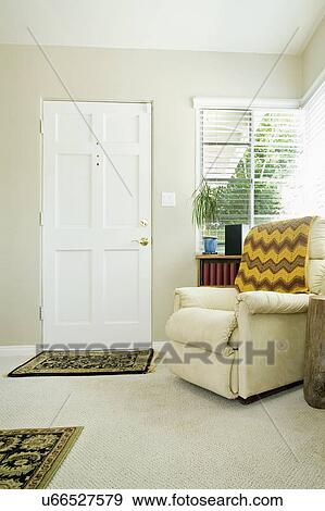 Stock Photo - Cozy armchair with throw blanket in living room, San Diego, California, United States of America. Fotosearch