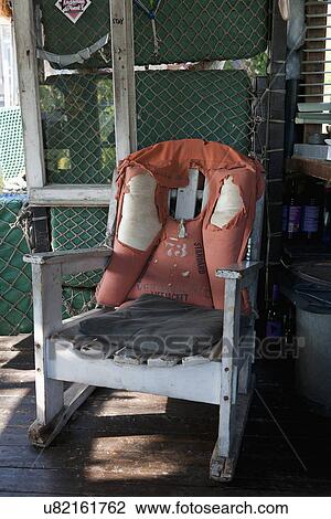 Damaged life jacket on wooden armchair View Large Photo Image Stock Image - Damaged life jacket on wooden armchair. Fotosearch