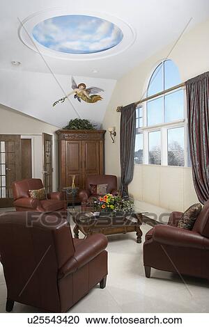 Stock Image - DAY SPA: Sitting area, leather club chairs, arched window with taffeta drapes, painted angel mural, armoire, cloud mural. Fotosearch
