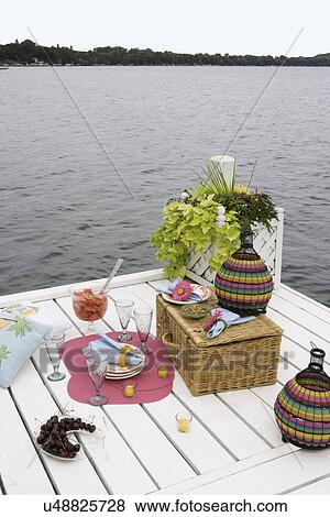 DECK: Overlooking Green Lake, Wi, picnic on pier, colorful dinnerware, basket, planter box at end of pier, vertical view View Large Photo Image Stock Photo - DECK: Overlooking Green Lake, Wi, picnic on pier, colorful dinnerware, basket, planter box at end of pier, vertical view. Fotosearch