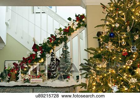 Decorated staircase banister and lit Christmas tree View Large Photo Image Stock Photo - Decorated staircase banister and lit Christmas tree. Fotosearch