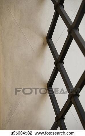 Stock Image - Detail adobe wall and wrought iron window grid; Irvine; California; USA. Fotosearch