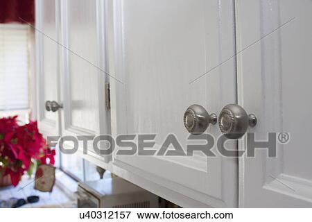 Stock Photo - Detail chrome knobs on kitchen cabinets; Trabuco Canyon; California; USA. Fotosearch