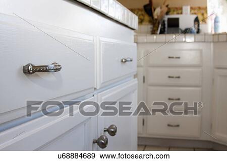 Stock Photo - Detail chrome knobs on kitchen cabinets; Trabuco Canyon; California; USA. Fotosearch