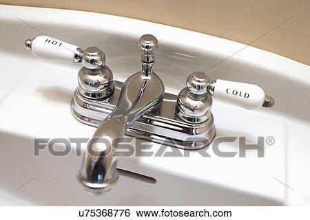 Stock Photograph - Detail faucet labeled hot and cold, Ojo Caliente, New Mexico, USA. Fotosearch
