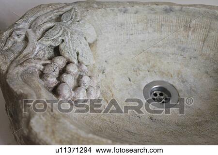 Picture - Detail grapes carved out of stone sink. Fotosearch