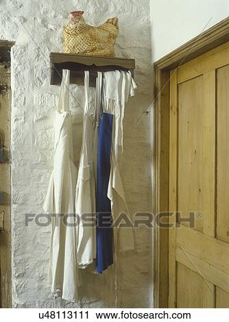 Detail of aprons hanging on white brick wall. England, partial doorway View Large Photo Image Stock Image - Detail of aprons hanging on white brick wall. England, partial doorway . Fotosearch