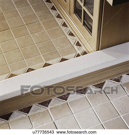 Stock Image - Detail of designed ceramic tiled ceiling in kitchen with partial view of wood cabinet. Fotosearch