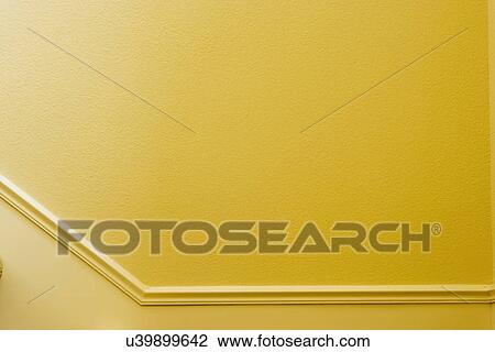 Stock Image - Detail of yellow wall with wainscoting; Oxnard; California; USA. Fotosearch