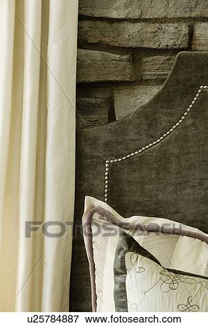 Stock Photo - Detail velvet headboard stone wall decorative pillows; Aliso Viejo; California; USA. Fotosearch