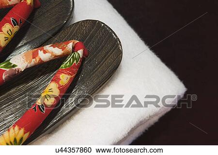 Stock Image - Detail wooden spa sandals on stack of towels; Aliso Viejo; California; USA. Fotosearch
