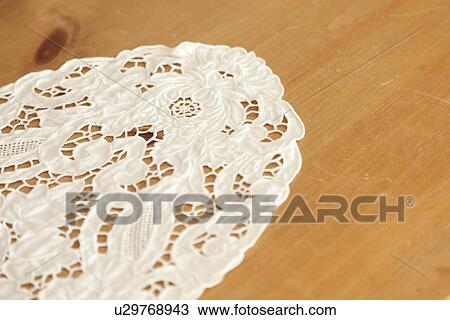 Stock Image - Doily on wooden table; Burbank; California; USA. Fotosearch