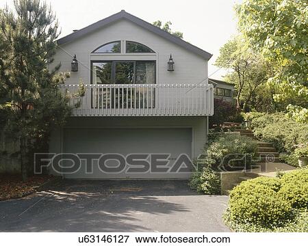 Stock Photo - Driveway leading to garage of a traditional house. Fotosearch