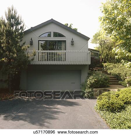 Stock Photograph - Driveway leading to garage of a traditional house. Fotosearch