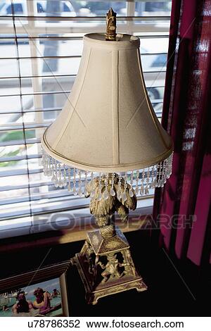 Stock Image - Elegant lamp on end table. Fotosearch