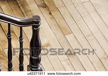 Stock Image - End of wooden banister against hardwood floor; Aliso Viejo; California; USA. Fotosearch