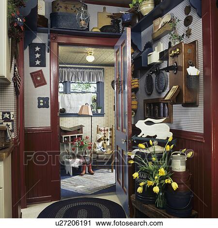 Stock Image - entry ways: view to mud room from kitchen, heavily decorated with country flare, old farmhouse, wainscoting and trim painted red, vintage wood crank phone on wall. Fotosearch