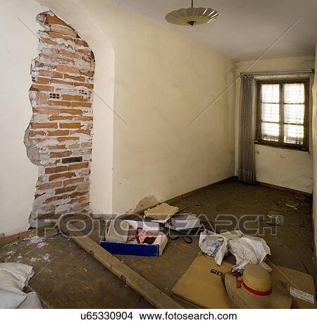 Picture - Exposed brick wall in abandoned living room, Albiano d'Ivrea, Italy. Fotosearch