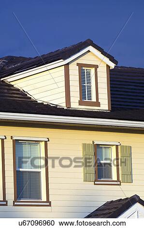 Stock Image - Exterior detail of average home with gable dormers. Fotosearch