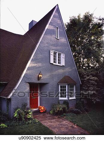 Stock Photography - Exterior gray cottage style house with pointed roof and red door at Chico; California; USA. Fotosearch