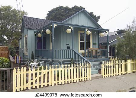 Stock Photo - Exterior green American Craftsman styled bungalow with yellow fence; Pacific Grove; California; USA. Fotosearch