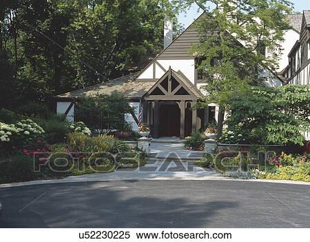 Stock Photography - Exterior of a cottage style house with garden in foreground. Fotosearch