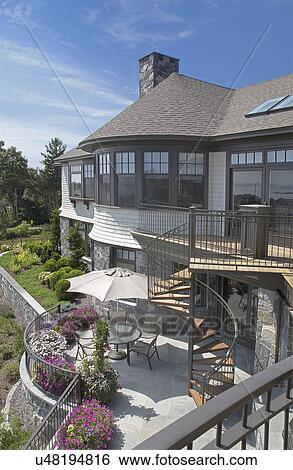 Exterior of a single family home with spiral staircase leading to yard View Large Photo Image Stock Photograph - Exterior of a single family home with spiral staircase leading to yard. Fotosearch
