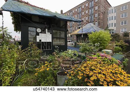 Stock Image - Exterior of cottage with flower garden. Fotosearch