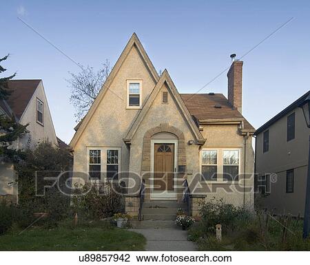 Stock Image - Exterior view of a beige cottage with angled roof tops; Minneapolis; Minnesota; MN. Fotosearch