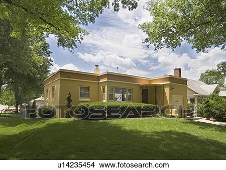 Picture - Exterior view of a yellow house with front yard at Lincoln; Nebraska; USA. Fotosearch