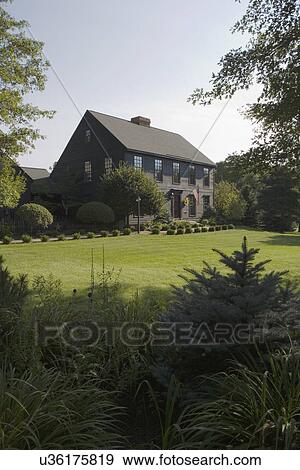 EXTERIORS: Dark brown salt box style home, sweeping lawns, gardens, American flag, vertical, garden in foreground View Large Photo Image Stock Photo - EXTERIORS: Dark brown salt box style home, sweeping lawns, gardens, American flag, vertical, garden in foreground. Fotosearch