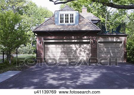 EXTERIORS: GARAGE: Non attached brick three car, two story garage with 2nd floor balcony/ deck, cedar shake roof, dormer, blacktop driveway STRAIGHT ON VIEW View Large Photo Image Stock Photo - EXTERIORS: GARAGE: Non attached brick three car, two story garage with 2nd floor balcony/ deck, cedar shake roof, dormer, blacktop driveway STRAIGHT ON VIEW. Fotosearch