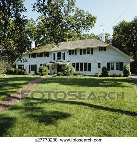 EXTERIORS: large graceful symmetric white frame house, large front lawn with brick walkway View Large Photo Image Stock Photo - EXTERIORS: large graceful symmetric white frame house, large front lawn with brick walkway. Fotosearch