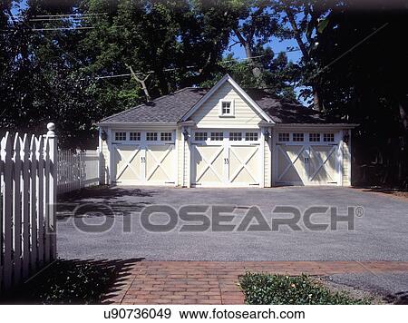 EXTERIORS: Non-attached three car garage, pale yellow / white trim / new construction that was made to compliment Victorian Home, pull out doors, white picket fence on left. View Large Photo Image Stock Photo - EXTERIORS: Non-attached three car garage, pale yellow / white trim / new construction that was made to compliment Victorian Home, pull out doors, white picket fence on left.. Fotosearch