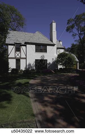 EXTERIORS: white brick French Normandy style home with red brick driveway View Large Photo Image Stock Image - EXTERIORS: white brick French Normandy style home with red brick driveway. Fotosearch