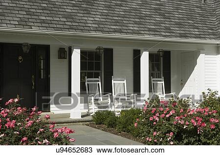 EXTERIORS: White traditional home with black shutters, front porch, pinker rose bushes, close up of front entry, covered porch with white rocking chairs, View Large Photo Image Stock Image - EXTERIORS: White traditional home with black shutters, front porch, pinker rose bushes, close up of front entry, covered porch with white rocking chairs,. Fotosearch