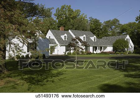 EXTERIORS: White traditional home with black shutters, front porch, pink rose bushes, lawn, blacktop driveway, three dormers can be seen from this angle view, distant shot View Large Photo Image Stock Photograph - EXTERIORS: White traditional home with black shutters, front porch, pink rose bushes, lawn, blacktop driveway, three dormers can be seen from this angle view, distant shot. Fotosearch