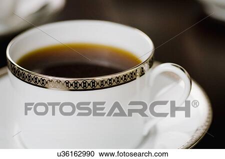 Stock Image - Extreme close-up of cup of coffee on saucer. Fotosearch